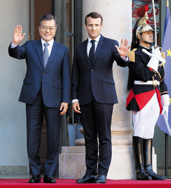 문재인 대통령이 15일(현지 시각) 프랑스 대통령궁인 엘리제궁에 도착해 에마뉘엘 마크롱 프랑스 대통령과 함께 취재진을 향해 인사하고 있다. 