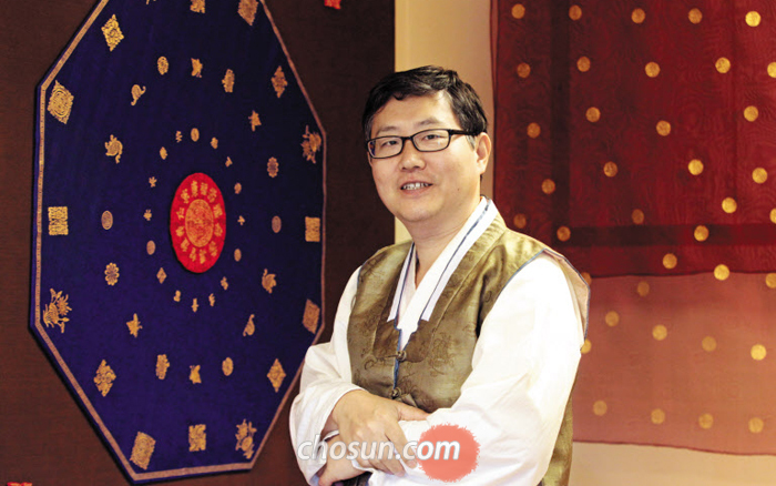 서울 북촌 공방에서 만난 금박장 김기호씨는 “100년 뒤에도 인정받을 수 있는 작품을 남기고 싶다”고 했다. 김씨의 뒤에 금박 문양이 찍힌 보자기(왼쪽)와 면사포가 걸려 있다.