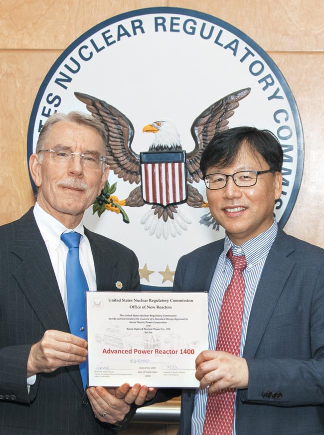 지난 9월 28일 한수원 안대근 워싱턴DC 센터장(오른쪽)이 NRC 관계자들로부터 APR1400원전설계승인서를 전달 받고 있다.
