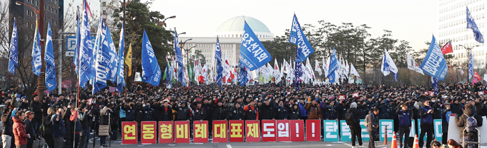 국회 앞 8차선 도로 모두 막고… - 지난 1일 오후 민노총을 비롯한 좌파 단체 50여곳으로 구성된 민중공동행동이 서울 여의도 국회 앞에서 ‘2018 전국민중대회’를 열고 ‘연동형 비례대표제’ 도입을 촉구하고 있다. 연동형 비례대표제는 정당 득표율을 의석 수와 정확하게 맞춰주자는 제도로, 2016년 20대 총선에 도입됐다면 정의당 의석이 6석에서 12석으로 2배가 된다. 이날 집회에서는 이 외에도 쌀값 인상, 국가보안법 폐지, 이석기 석방 등 여러 요구가 쏟아졌다.