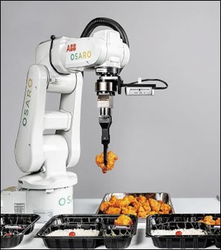 오사로에서 만든 로봇 팔이 적당한 크기와 무게의 닭 조각을 집게로 집어 도시락 박스에 담고 있다.