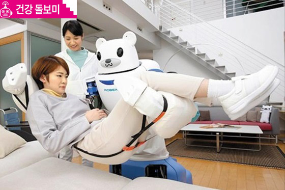 일본에서 개발된 간병 로봇 ‘로베어’가 환자를 양팔로 들어 올려 침대에 올려놓고 있다.