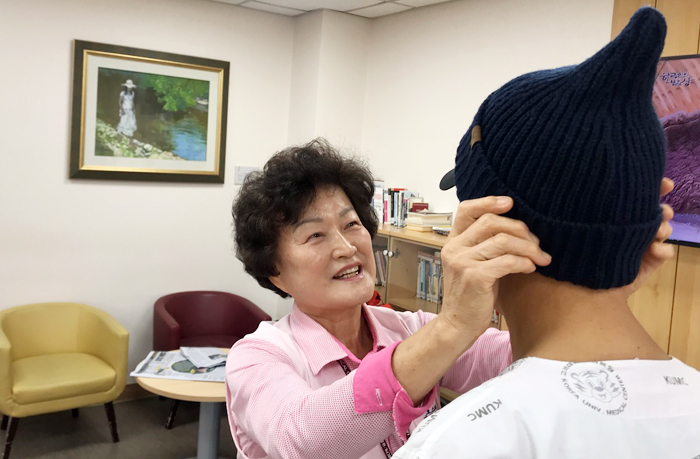 지난달 11일 오후 고려대 안암병원의 암 병동에서 ‘1세대 호스피스’ 김영원 (사진 왼쪽)씨가 50대 남성 환자에게 방한용 털모자를 씌워주고 있다. 