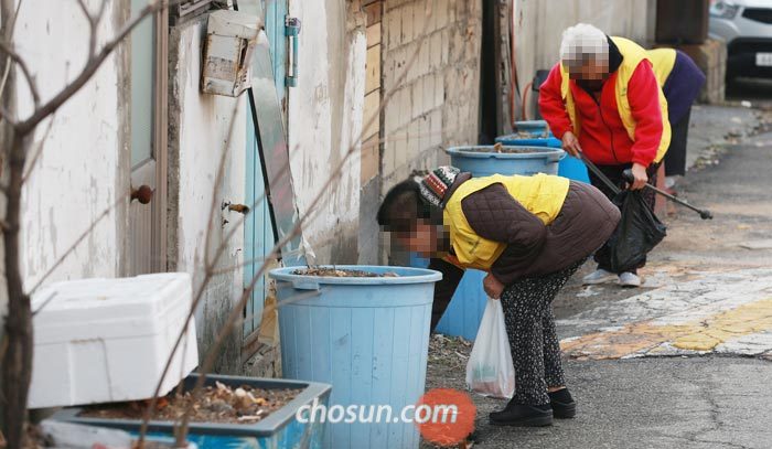 서울 노원구 중계동 백사마을 골목에서 노인들이 쓰레기 등을 줍고 있다.