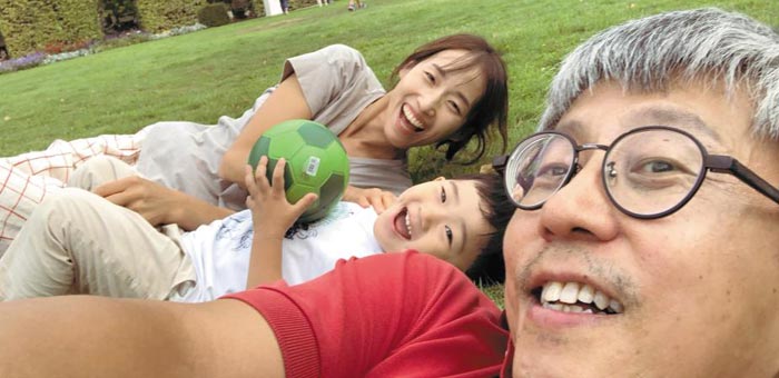 지난해 8월 독일 서부 도시 트리어의 한 시내 공원에서 정재훈(오른쪽) 교수와 아내가 잔디밭에 누워서 아들과 함께 웃고 있다.
