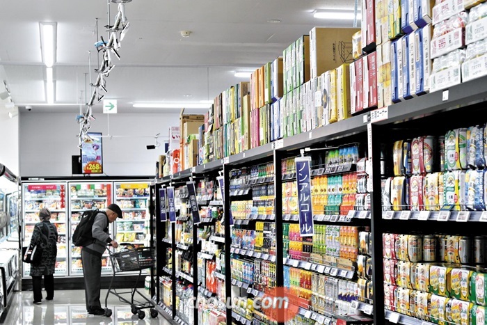 일본의 첫 심야 무인 마트 트라이얼퀵에서 70대 쇼핑객이 물건을 고르고 있다. 상품진열대의 통로 천장에 인공지능(AI)카메라가 빼곡히 매달려 있다.