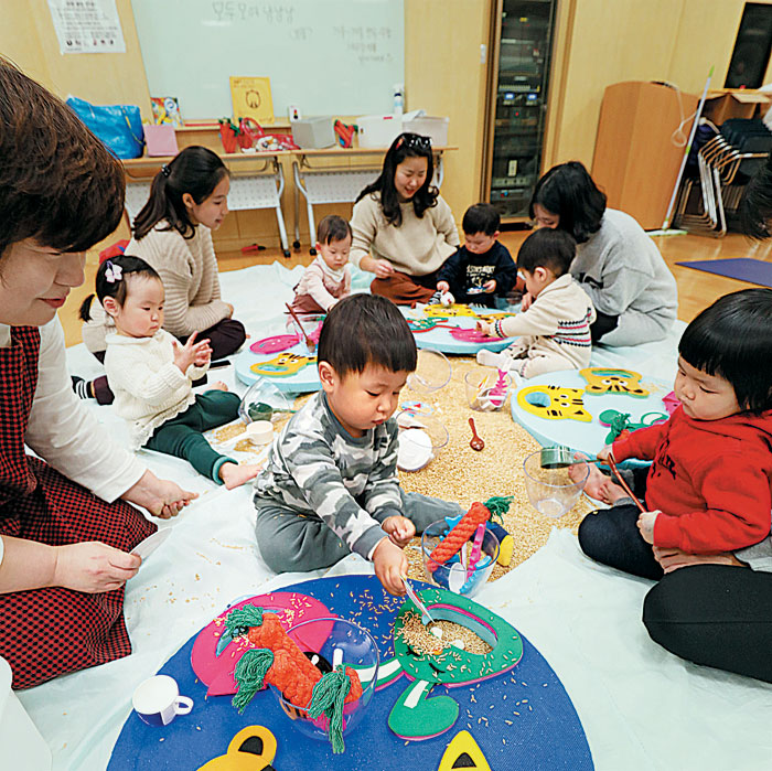 서울 이마트 성수점 문화센터에서 부모와 아이들이 곡물을 이용해 감각을 키우는 '북이랑 놀이랑'을 수강하는 모습.