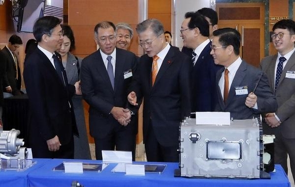 문재인 대통령이 1월 17일 오전 울산시청 대회의실에서 열린 ‘수소 경제와 미래 에너지, 울산에서 시작됩니다’ 행사에 참석하기에 앞서 수소 활용 전시장을 둘러보고 있다. 문 대통령(가운데)이 수소 활용 모빌리티 부스를 둘러보다 정의선(앞줄 왼쪽 두번째) 현대차 부회장에게 수소차 넥소에 대해 질문하고 있다. /연합뉴스