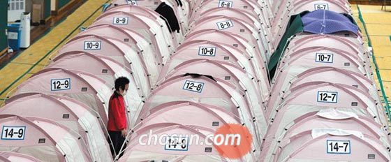 20일 경북 포항시 북구 흥해실내체육관에 마련된 임시 구호소에 지진 이재민이 텐트 사이로 걸어가고 있다. 2017년 11월 포항에 규모 5.4의 강진이 발생한 지 1년이 넘었지만 여전히 30여 명의 이재민이 피난 생활을 하고 있다.