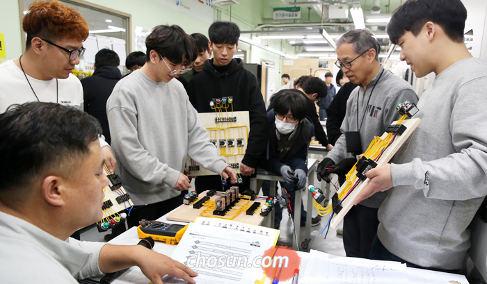 2일 서울 강동구 동부기술교육원의 전기계측제어과 학생들이 작업을 마친 전기설비제어판을 김이훈(왼쪽 아래) 교수에게 가져가 검사를 받고 있다. 취업난과 자영업 불황이 계속되면서 동부기술교육원에는 기술을 배우려는 20대와 화이트칼라 퇴직자가 늘고 있다.