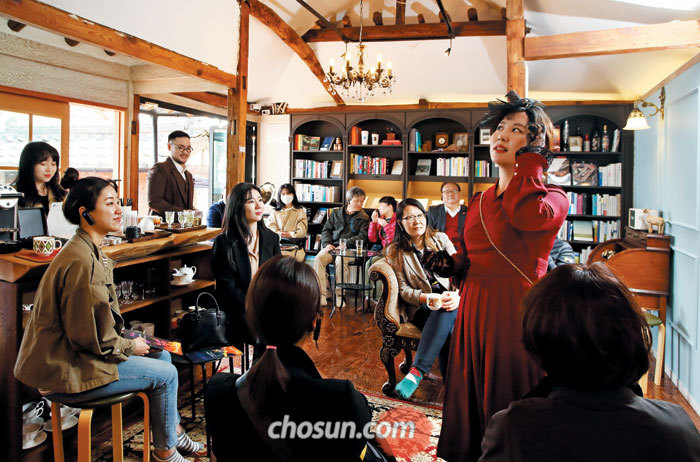 시간 여행을 안내하는 '광주 100년의 이야기' 버스의 가이드이자 배우, 가수이기도 한 '나비'역의 배우가 양림쌀롱에서 연기 중이다.