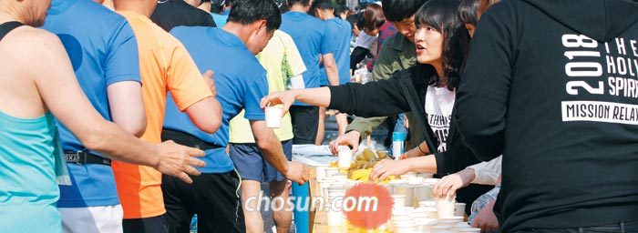 2018년 서울하프마라톤에서 자원봉사자들이 주자들에게 생수를 나눠주는 모습.
