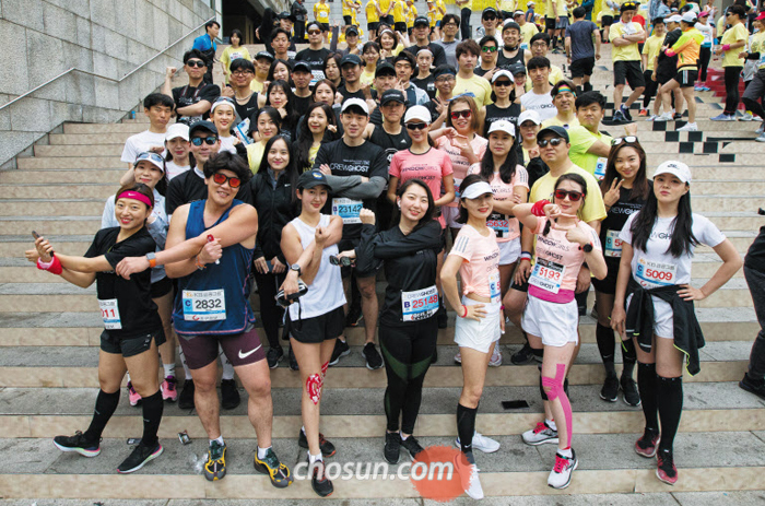 스마트폰에서 만나 서울하프마라톤에 단체로 참가한 ‘크루 고스트(Crew Ghost)’ 회원들이 서울 광화문광장 출발점에서 몸풀기를 준비하고 있다. 이들은 앱을 통해 달리기 모임 일정을 정하며, 달린 다음엔 뒤풀이도 없이 곧바로 흩어진다고 해서 이름을 크루 고스트라 붙였다.