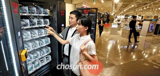 지난 7일 서울 송파구 롯데백화점 잠실점에서 손님들이 무인(無人) 키오스크에서 미세 먼지 차단용 마스크를 고르고 있다.