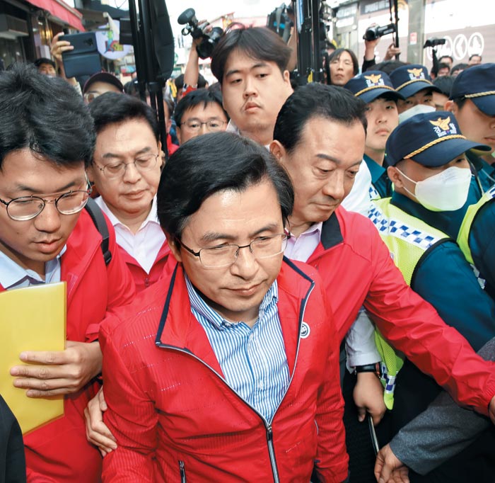 '민생 대장정' 중인 자유한국당 황교안 대표가 14일 오후 학부모 간담회를 위해 충북 청주 상당구의 한 커피점으로 가던 중 민노총 조합원들이 시위를 벌이는 바람에 경찰의 도움을 받으며 이동하고 있다.