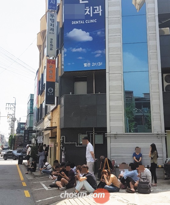 지난해 압구정 투명치과 측이 본관 문을 닫고 좁은 별관에서 한정된 인원만 진료한다고 밝히면서 환자들이 땡볕에 줄을 서 있는 모습.