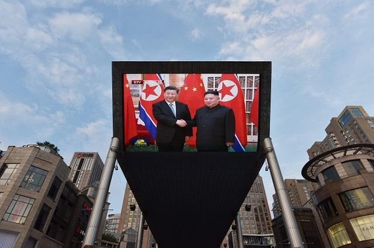  2019년 6월 20일 중국 베이징 시내 한 전광판에서 시진핑 중국 국가주석과 김정은 북한 국무위원장이 이날 평양에서 만나 악수를 하고 있는 모습이 중계되고 있다. /AFP 연합뉴스
