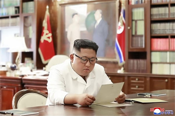  조선중앙통신이 23일 홈페이지에 공개한 사진에서 김정은 북한 국무위원장이 집무실로 보이는 공간에서 트럼프 대통령의 친서를 읽는 모습. /연합뉴스