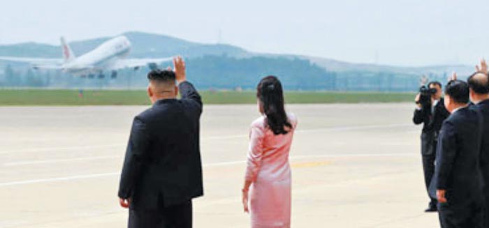 김정은 북한 국무위원장 부부가 지난 21일 평양 국제비행장에서 시진핑 국가주석이 탄 비행기를 향해 손을 흔들고 있다.