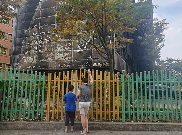 27일 오전 서울 은평구 응암동 은명초등학교 앞에서 학생과 학부모가 불에 탄 건물을 보고 있다. /최지희 기자