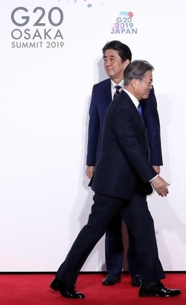  문재인 대통령이 2019년 6월 28일 오전 인텍스 오사카에서 열린 G20 정상회의 공식환영식에서 의장국인 일본 아베 신조 총리와 악수한 뒤 이동하고 있다. /연합뉴스