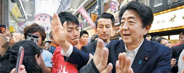 참의원 선거 유세에 나선 아베 신조(安倍晋三·오른쪽) 일본 총리가 6일 오사카(大阪)의 한 상점가에서 유권자들에게 둘러싸여 손을 흔들고 있다. /연합뉴스