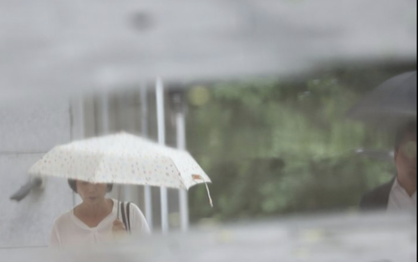 전국이 장마전선의 영향권에 들어간 지난 11일 오전 서울 시내의 한 인도에 고인 빗물 위로 우산을 든 시민들의 모습이 비치고 있다./연합뉴스
