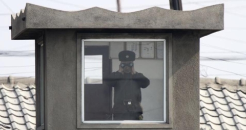 북한 국경 신의주의 한 초소에서 북한 보안원이 감시를 하고 있다./VOA 제공