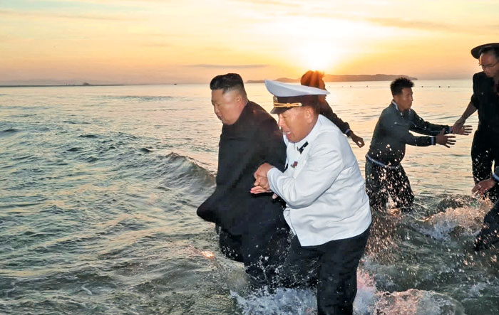 김정은 북한 국무위원장이 지난 24일 인민복 차림으로 바다에 들어가 참모들과 함께 '초대형 방사포' 발사장으로 걸어가는 모습을 조선중앙TV가 25일 밤 공개했다.
