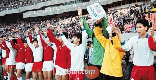 1990년 10월 23일 잠실주경기장에서 열린 통일축구대회 2차전이 끝난 뒤 만세를 부르는 남북 축구 선수들. /조선일보DB