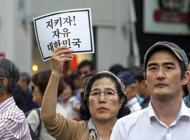 조국 법무부 장관 퇴진을 요구하는 집회가 열린 10월 3일 오후 서울 광화문 동화면세점 빌딩 앞에서 한 시민이 자유 대한민국을 지키자는 구호가 담긴 종이를 들고 있다. /조인원 기자