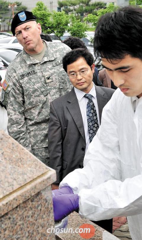 경북 칠곡군 주한미군 기지‘캠프 캐럴’의 고엽제 매몰 의혹이 제기된 가운데 27일 한·미 공동조사단이 캠프 캐럴 인근 교육문화복지회관 급수대에서 지하수 시료(試料)를 채취하고 있다. 이날 한·미 공동조사단은 캠프 캐럴 밖 10여곳의 지하수 관정(管井)에서 물을 떠가 다이옥신 검출 여부 등 수질 검사를 시작했다. /남강호 기자 kangho@chosun.com