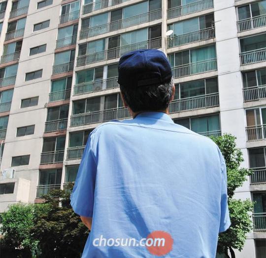 서울 동작구의 한 아파트에서 경비원으로 일하고 있는 양원진(가명·62)씨가 자신이 근무하는 아파트를 올려다보고 있다. 일반 기업에서 근무하다 퇴직한 양씨는 딸과 아들의 결혼비용을 마련하기 위해 경비원으로 재취업했다. /김효인 기자 hyoink@chosun.com