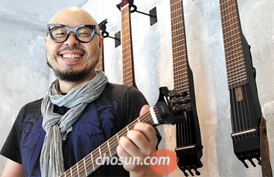기타리스트 이병우(48)가 서울 삼성동에 있는 자신의 기타 가게에서 직접 제작한 ‘기타 바(Guitar Bar)’를 들고 있다. 이씨는 “스페셜올림픽과 뮤직페스티벌 일을 하면서 제 자신이 배우는 게 참 많다”고 했다