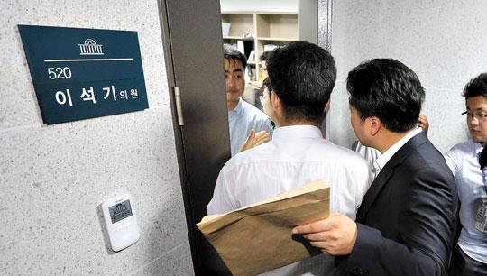 29일 오후 국회 의원회관의 통합진보당 이석기 의원 사무실에서 국가정보원 직원들이 압수수색 영장이 든 봉투를 들고 들어가고 있다.