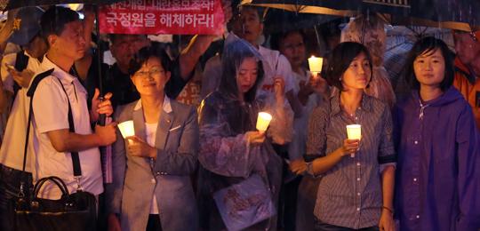 지난 31일 서울역 광장에서 열린‘국정원 대선 개입 규탄 10차 범국민 촛불 집회’에 통합진보당 김재연(오른쪽 둘째) 의원 등이 참석해 빗속에 촛불을 들고 있다. 이날 집회 참석자들은‘불법 당선 박근혜 하야’‘내란 음모 조작 국정원을 해체하라’고 주장했다.