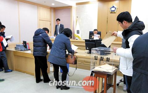 지난 4일 경기 의정부지방법원 고양지원 입찰 법정에서 경매 참가자들이 서류를 작성해 입찰함에 넣고 있다. 최근에는 젊은 층도 경매에 많이 참가하고 있다