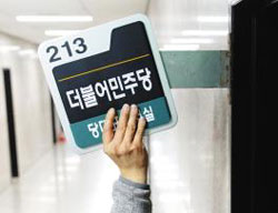 더불어민주당 관계자가 30일 오후 국회에 있는 문재인 대표 집무실 문패를 바뀐 당명에 맞게 교체하고 있다.
