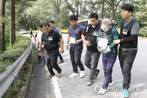 경기 용인동부경찰서는 15년 전 경기 용인의 한 단독주택에서 발생한 대학교수 부인 살인사건의 진범 김모 씨를 검거했다고 7일 밝혔다. 6일 현장검증 과정에서 김씨가 도주경로를 따라 범행을 재연하고 있다./연합뉴스