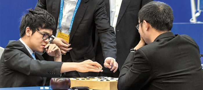 대국 종료 후 커제(왼쪽 앉은이)가 동료 기사들에게 둘러싸여 복기하는 모습. 커제는 155수 만에 백 불계로 허망하게 무너졌다.