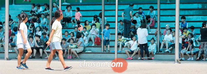 위험에 노출된 아이들 - 23일 오후 2시 민방공 대피훈련이 실시된 서울의 한 초등학교 학생들이 교실에서 나와 운동장 옆 스탠드로 이동해 앉아 있는 모습. 학교가 북한의 장사정포·미사일 공격을 받을 경우 운동장은 가장 위험에 노출되는 곳이다. 반드시 건물 지하나 대피소로 이동해야 한다.
