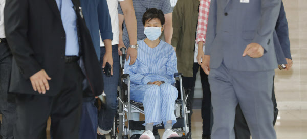 환자복을 입은 박근혜 전 대통령이 30일 서울 서초동 서울성모병원에서 허리 통증으로 진료를 받은 뒤 휠체어를 타고 병원을 나서고 있다. /연합뉴스