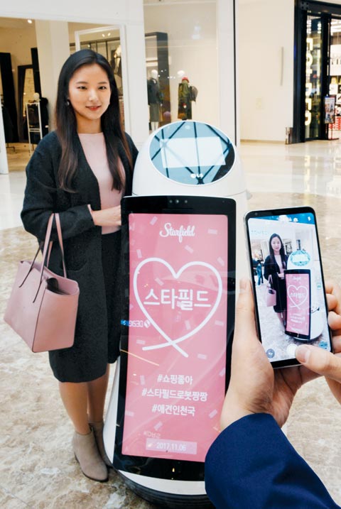 7일 복합 쇼핑몰 스타필드 하남에서 한 고객이 LG전자가 개발한 안내 로봇과 함께 기념사진을 찍고 있다.