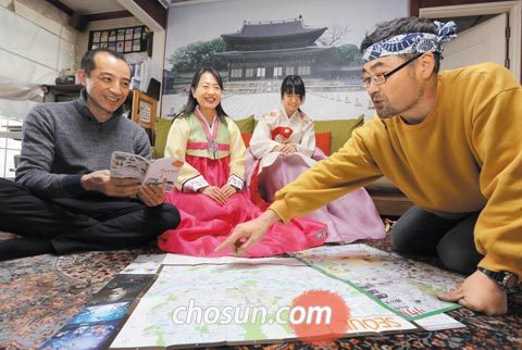 5일 오후 서울 용산구 후암동‘쯔요시노이에’게스트하우스에서 김희웅(오른쪽) 대표가 도쿄에서 온 오에 요시아키씨 가족에게 지도를 펼쳐놓고 서울 명소를 소개하고 있다.