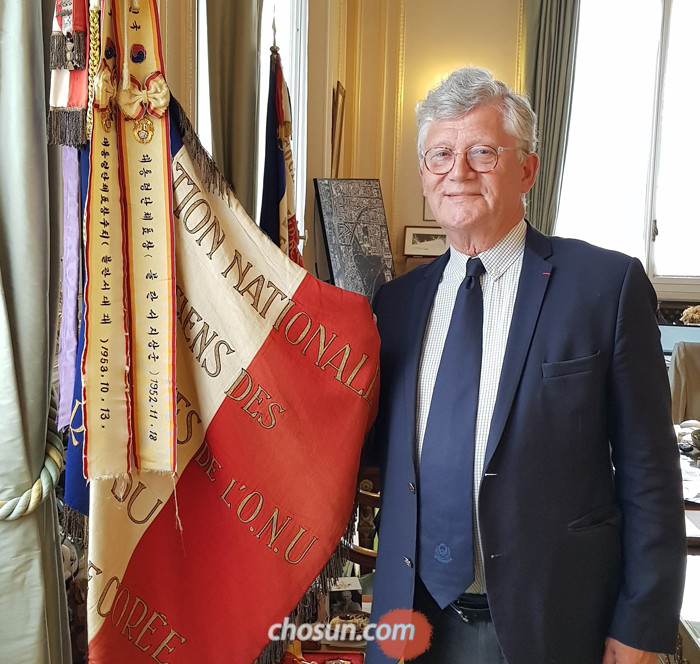 프랑스의 6·25 전쟁 참전용사협회장인 파트리크 보두앵 생망데市 시장이 집무실에 걸어둔 표창기(旗)를 들어 보이고 있다. 6·25 전쟁 당시 이승만 대통령이 프랑스군에 수여한 것이다. 