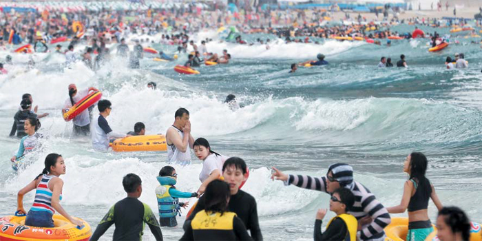 휴가 절정… 어제 50만명이 해운대로 - 29일 오후 부산 해운대구 해운대해수욕장에서 피서객들이 물놀이를 즐기고 있다. 부산시에 따르면 이날 50만명이 해운대해수욕장을 찾았다. 이 외에도 광안리, 송정 등 부산 해수욕장 7곳을 찾은 피서객은 이날 하루 총 214만3000명으로 올해 최대 인파를 기록했다.
