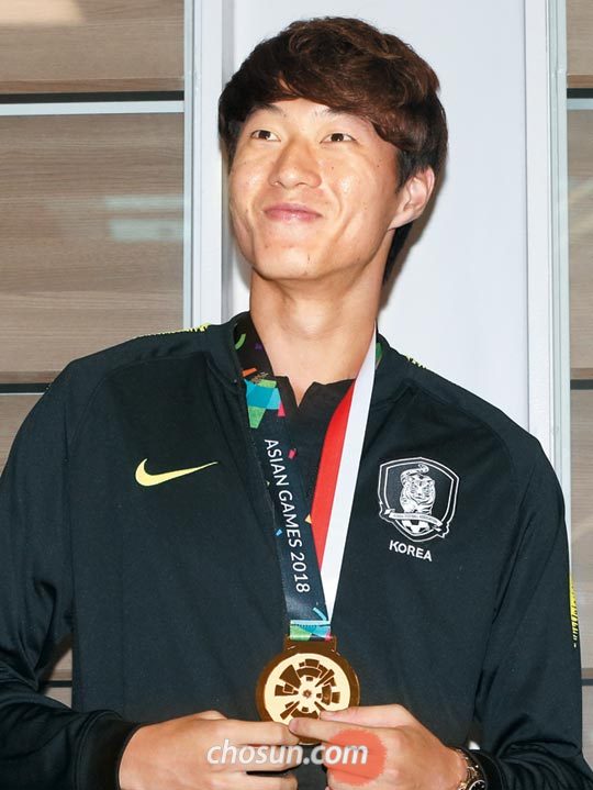 아시안게임 금메달을 목에 걸고 귀국한 황의조가 환호하는 팬들을 바라보고 있다.
