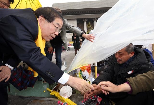 박원순 서울시장이 2015년 4월 14일 서울 광화문광장에서 세월호 유가족이 머물고 있는 광장 내 비닐천막으로 들어가 유가족을 위로하고 있다. /조선일보DB