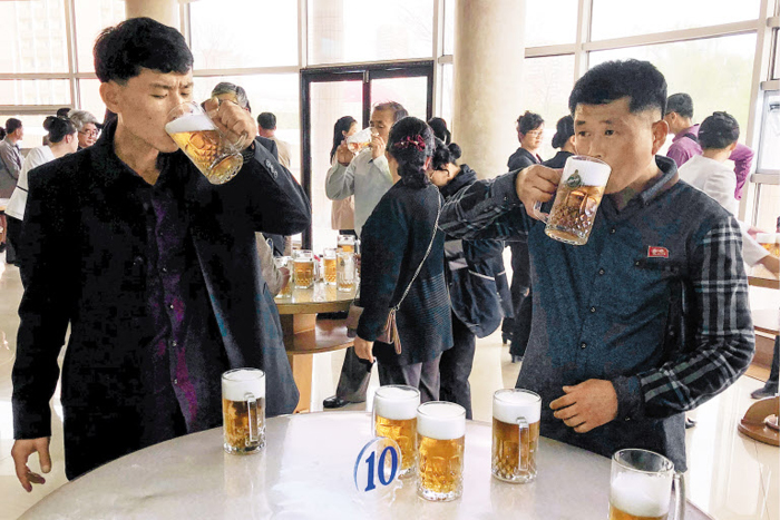 선 채로 생맥주 마시는 평양 주민들 - 북한 주민들이 지난 23일 평양 보통강변에 있는 ‘만수교 청량음료점’에서 선 채로 생맥주를 마시고 있다. 테이블 위에 맥주잔들이 가득하다. 최근 북한은 김정은 국무위원장의 지시로 유엔 등 국제사회에 식량난을 호소하고 있다.