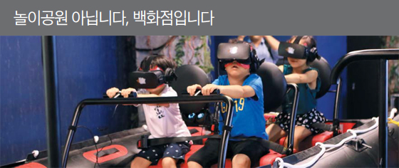 어린이들이 롯데백화점 건대점 10층에 있는 가상현실 실내 테마파크에서 놀이기구를 즐기는 모습. 60개 이상의 VR 콘텐츠가 마련돼 있다. 1400㎡의 공간에서 100명이 동시 탑승할 수 있다고 한다.